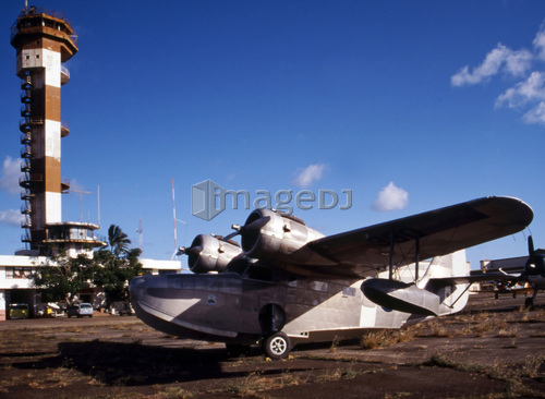Antique Navy Seaplane parked in front of the World War II Control Tower on Ford Island, Pearl Harbor, Hawaii.