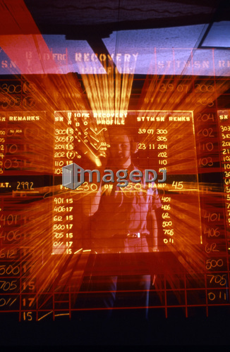 An officer demonstrates writing backward on the clear air traffic control status board.