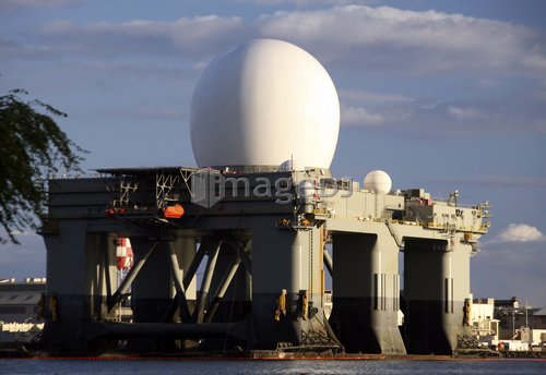 Sea Based X-band Radar dome modeled by the setting sun at Pearl Harbor naval shipyard.