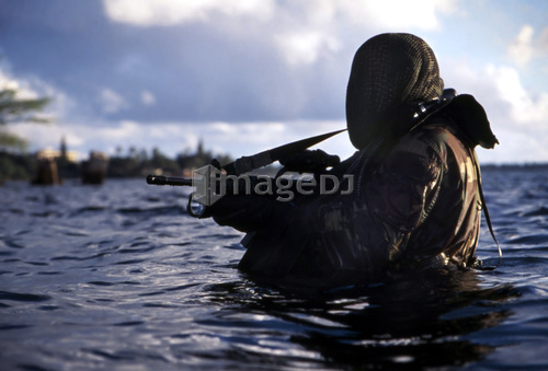 A Navy SEAL emerges from underwater during a training exercise.