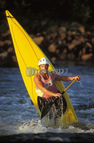young man performs ender in c-1 canoe on the Ottawa river, Ontario, Canada