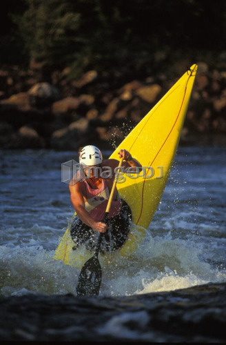 young man performs ender in c-1 canoe on the Ottawa river, Ontario, Canada