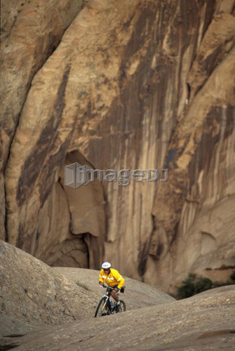 young man mountain biking on Slickrock Trail near Moab, Utah, USA