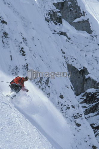 Young man skiing fresh powder on steep slope at Island Lake Resort, Fernie, British Columbia, Canada.