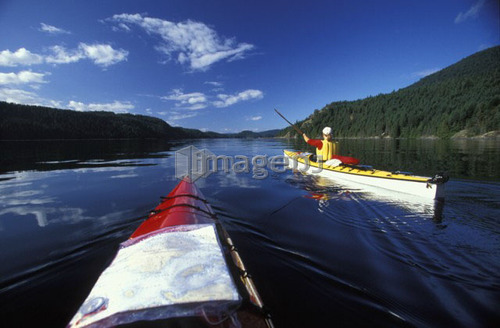 young woman sea kayaking near Curme Island, Desolation Sound Marine Park, British Columbia, Canada