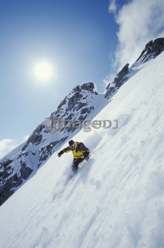 Young man skiing fresh powder on steep slope at Blackcomb Mountain, Whistler, British Columbia, Canada.