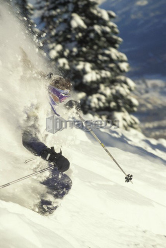 Young woman skiing deep powder at Fernie Alpine Resort, Fernie, British Columbia, Canada.