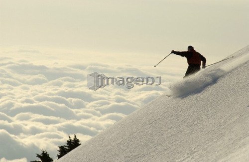 Silhouette of a skier above the clouds, Port Alberini, Vancouver Island, B.C.