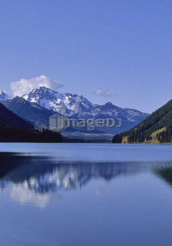The mountains above Carpenter Lake are reflected in early winter, B.C.