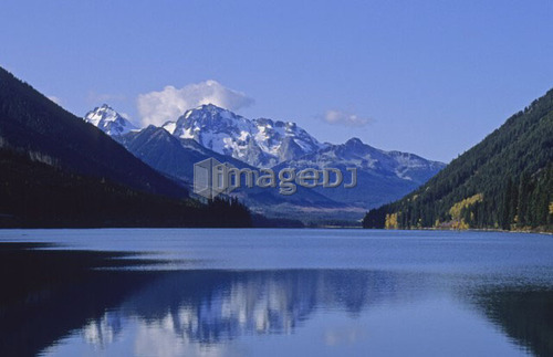 The mountains above Carpenter Lake are reflected in early winter, B.C.