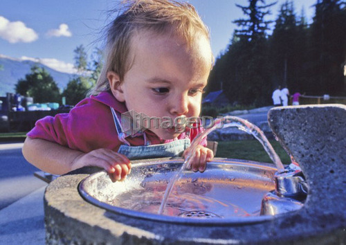 Girl, 3, drinks fresh water from fountain, Whistler, B.C.