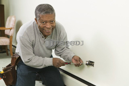 African American man working on a household receptacle, B.C.