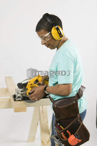 African American Woman Doing Home Improvement, Cutting Lumber With a Skill Saw, B.C.