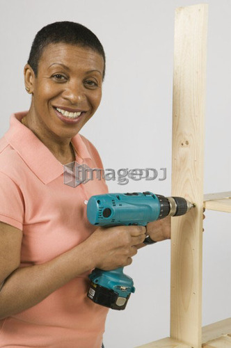 African American Woman Doing Home Improvement, Assembling a Shelving Unit, B.C.