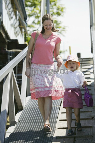 Caucasian Mom and 4 year old Daughter, walking down a ramp to a boat dock, Granville Island, Vancouver, B.C.