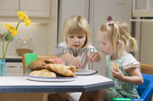 3 and 5 year old sisters having breakfast, B.C.