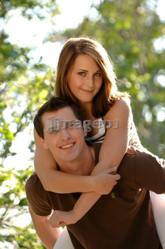 Teenage boy piggy backing teenage girl, Regina, Saskatchewan