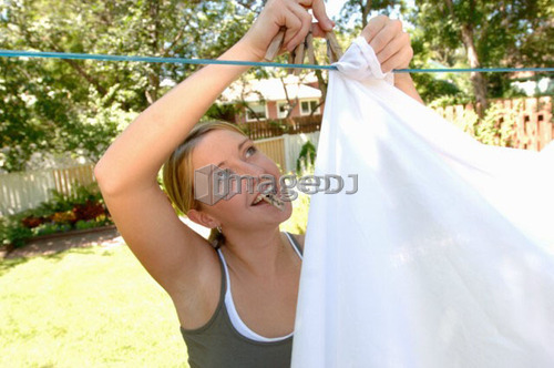 Young woman hanging laundry, Regina, Saskatchewan