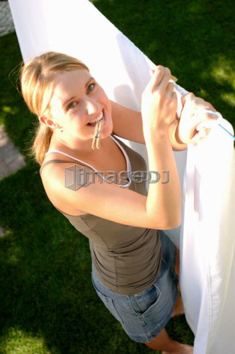 Young woman hanging laundry, Regina, Saskatchewan