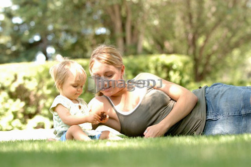 Young woman w/baby in grass, Regina, Saskatchewan