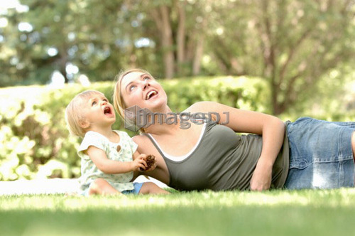 Young woman w/baby in grass, Regina, Saskatchewan