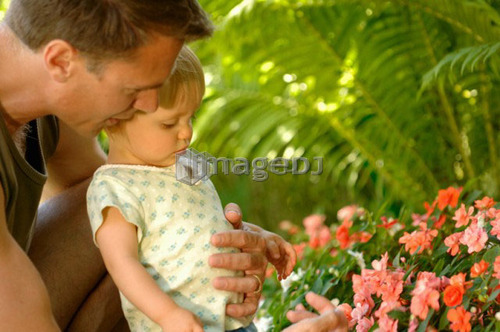 Dad & baby looking at/smelling flowers, Regina, Saskatchewan