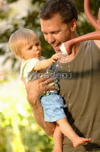 Dad & baby playing with watering can, Regina, Saskatchewan