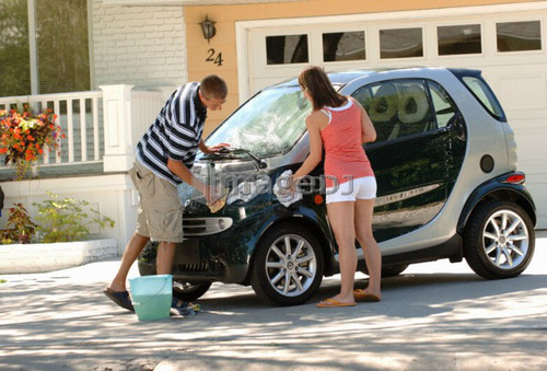 Teenage boy & girl washing smart car, Regina, Saskatchewan