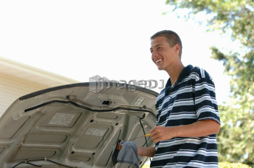 Teenage boy checking oil, Regina, Saskatchewan