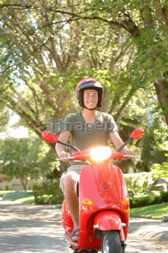 Teenage boy driving red vespa, Regina, Saskatchewan