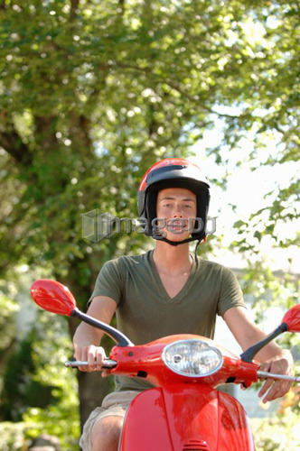 Teenage boy driving red vespa, Regina, Saskatchewan