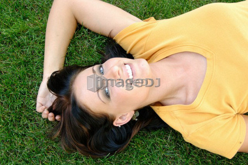 Young woman laying on grass, Regina, Saskatchewan