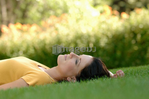 Young woman laying on grass, Regina, Saskatchewan