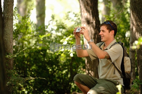 Young man in woods w/ camera, Regina, Saskatchewan