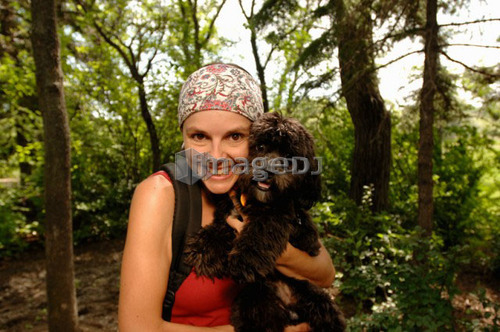 Woman hiker with dog in woods, Regina, Saskatchewan