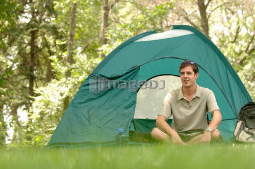 Young man sitting in front of tent, Regina, Saskatchewan