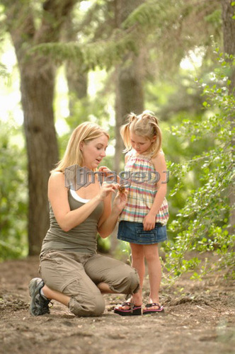 Young woman and child in woods looking at scenery, Regina, Saskatchewan
