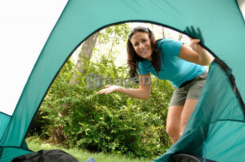 Young woman looking into opening of tent, Regina, Saskatchewan