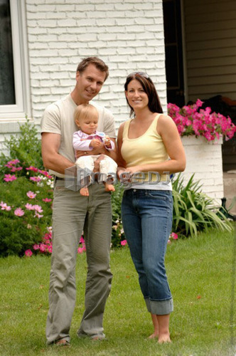 Young couple w/baby in front of house, Regina, Saskatchewan