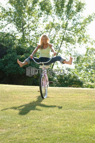 Young blonde woman riding bike down hill, Regina, Saskatchewan