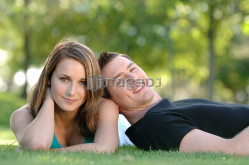 Boy and girl teenagers in grass at park, Regina, Saskatchewan