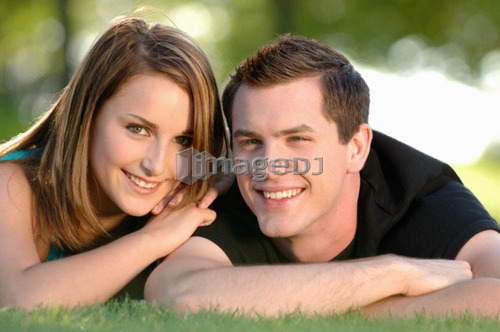 Boy and girl teenagers in grass at park, Regina, Saskatchewan