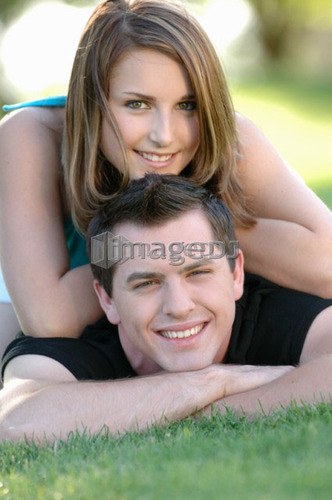 Boy and girl teenagers in grass at park, Regina, Saskatchewan