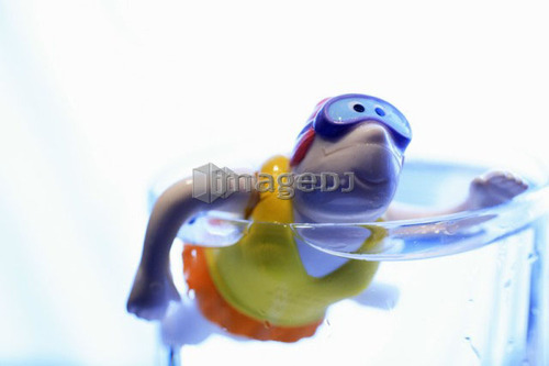 Child's bathtub toy in glass of water