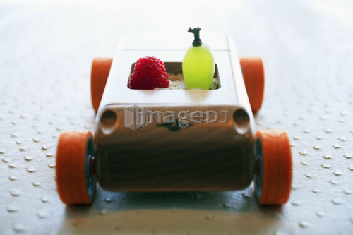 Grape and raspberry in wooden toy car