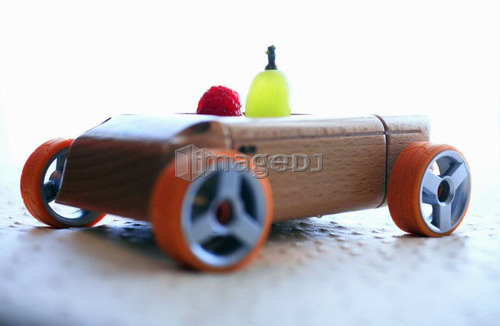 Grape and raspberry in wooden toy car