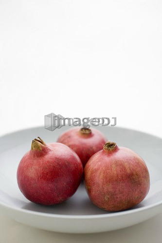 3 Pomegranates in low bowl