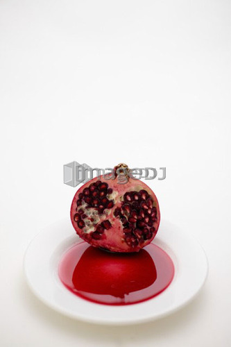 Half a pomegranate on a white plate