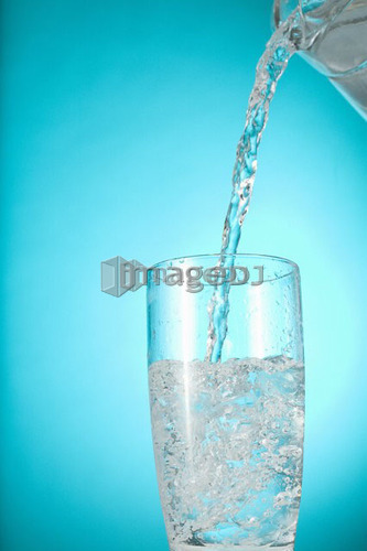 Pitcher of water pouring into clear glass