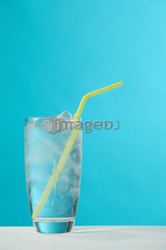 Clear glass of water with yellow drinking straw